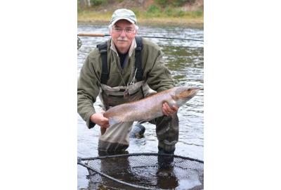 Author Ken Bailey on knee holds medium large fish