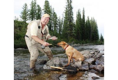 neil waugh fishing by stream with his dog