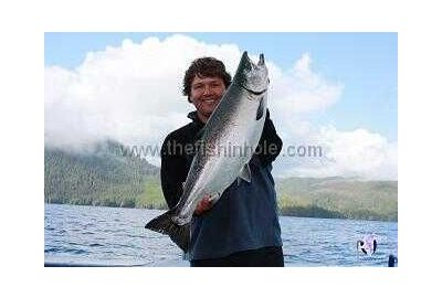 Fred Noddin standing and holding a medium large fish