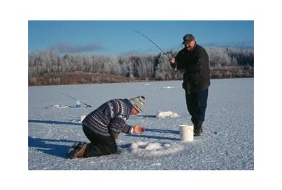 man kneels over to look into ice fishing hole adjusting line while another man is standing holding a fishing rod 