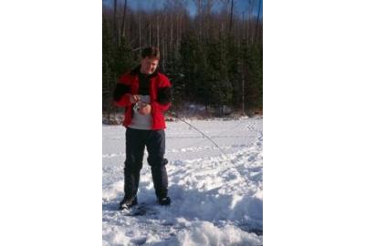 man standing in snow holding long fishing rod