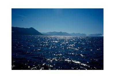 dark blue waters with mountains in the distance