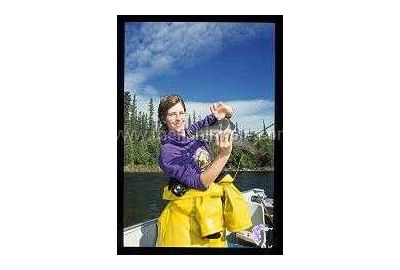 woman standing in boat holds a grayling 