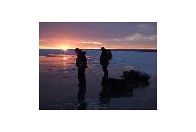 pink purple sunset on the ice with 2 fishermen