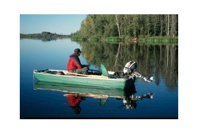 fisherman in a small green boat with motor on a lake