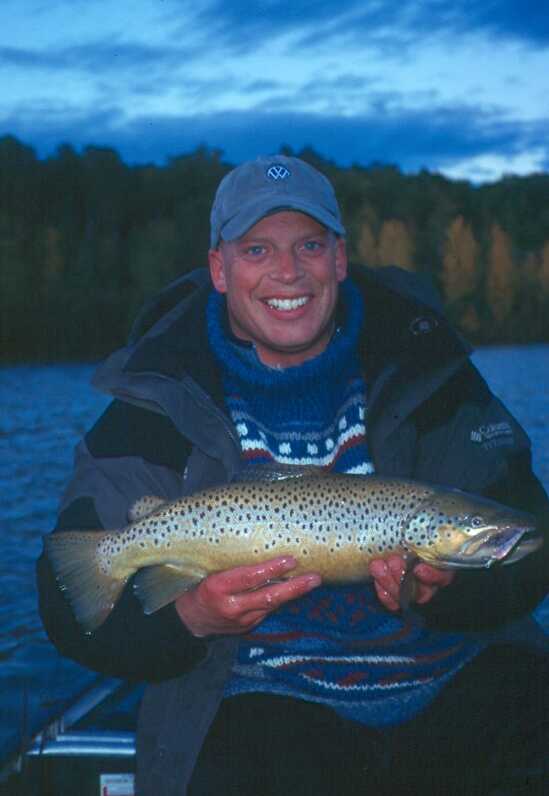 smiling man sitting holding fish