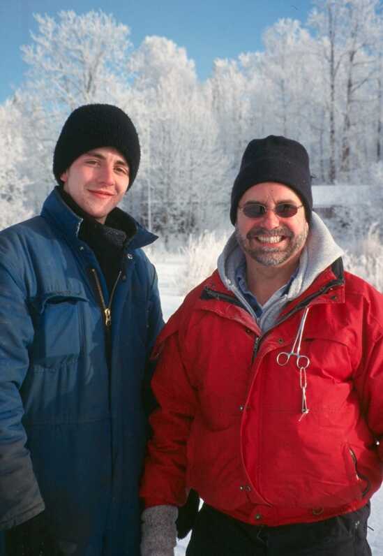 two men smiling wearing warm winter gear for ice fishing