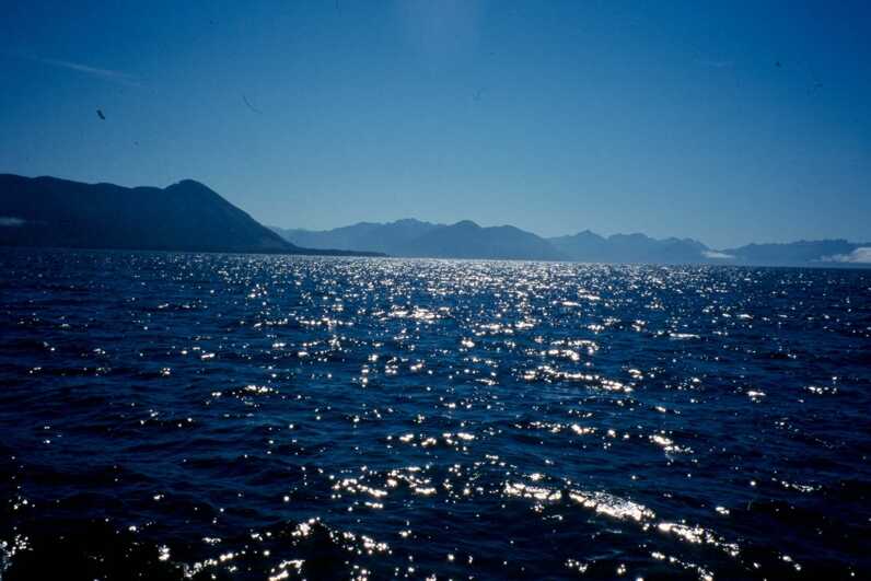 dark blue waters with mountains in the distance