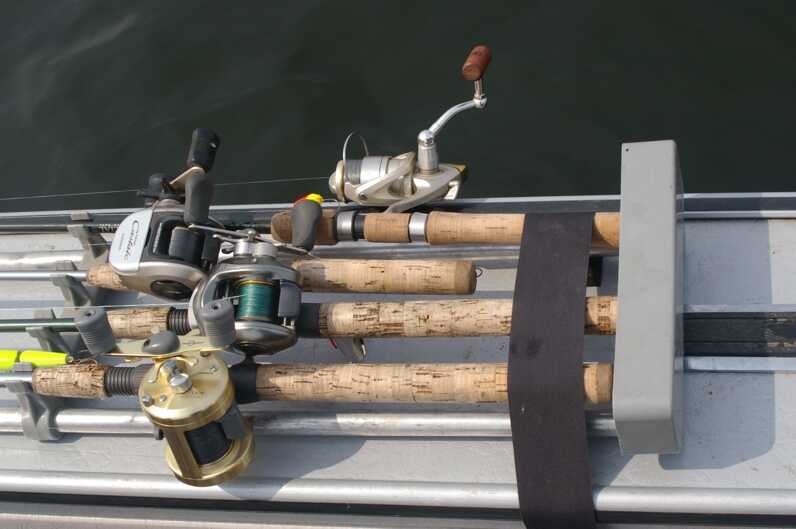 four fishing rods with reels strapped down in a case