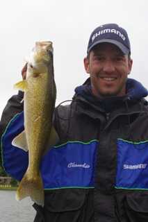 waist up portrait of a standing man holds a fish with his right hand