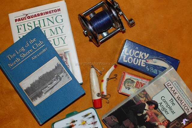 three fishing books and accessories mixed on flat surface