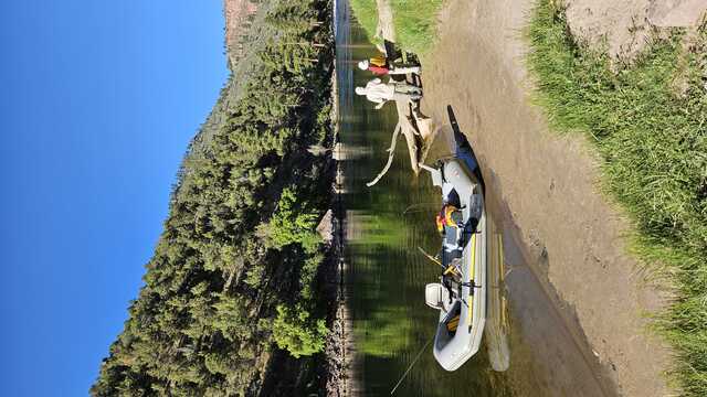 Two people and their inflated fishing boat on the shores of Green River Utah